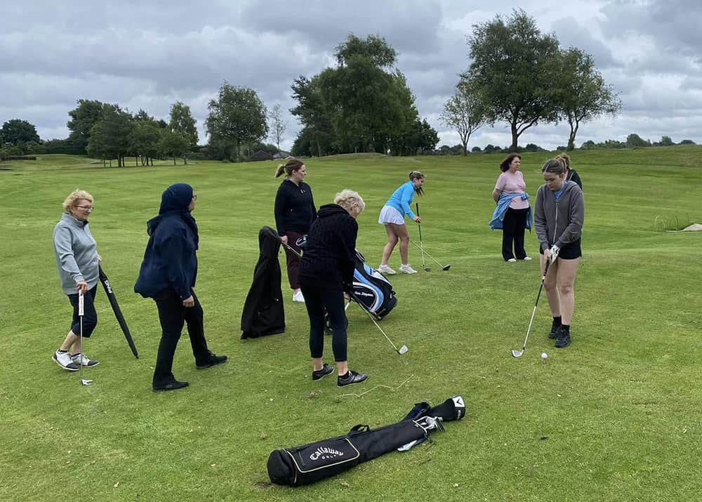 ladies being taught to play golf